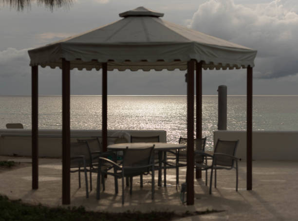 istock Gazebo by beach with sunset shining on water 802630658