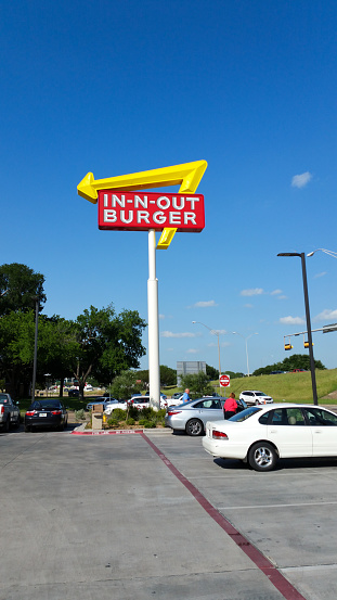 Waco, TX, USA - April 21, 2017; An In-N-Out Burger sign in Waco, TX in a parking lot with cars.  In-N-Out is known for a simple menu and is one of the famous restaurants in a handful of selected states in the USA.