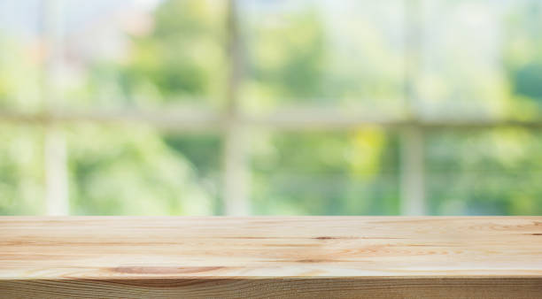 istock Wood table top on blur green garden from window view. 802644518