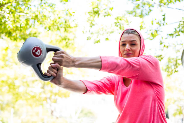 A pretty woman in a pink outfit doing exercise with a weight