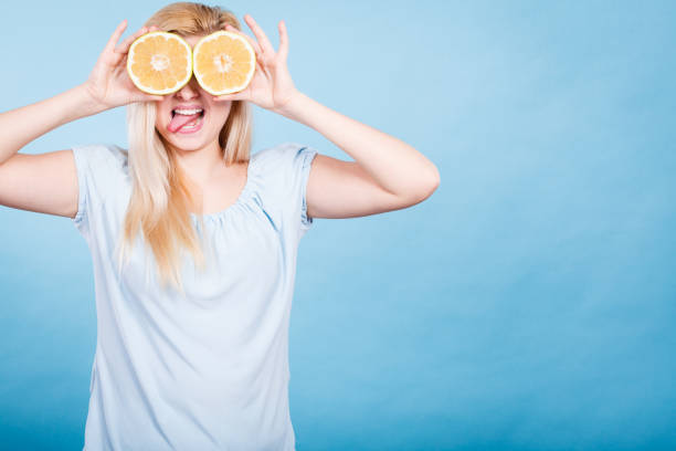istock Girl covering her eyes with grapefruits 802661584