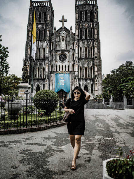 Woman walking in front of Saint Joseph cathedral in Hanoi Vietnam