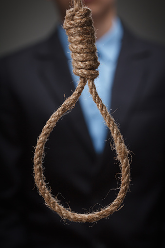 Desperate, hopeless depressed young man, is about to hang himself on the noose.