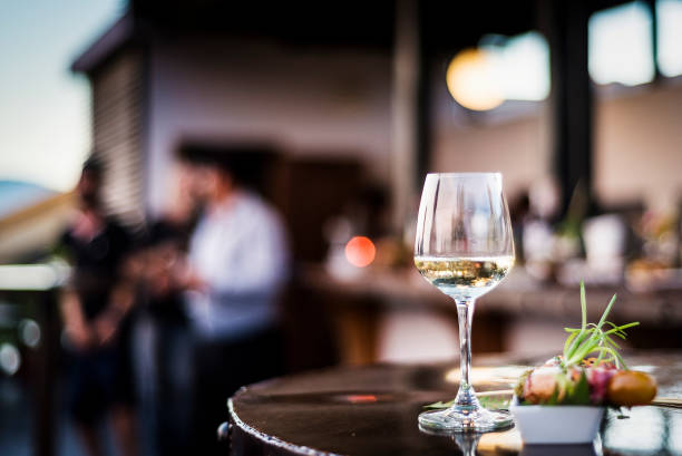 vaso de vino blanco con refrigerios de tapa de comida gourmet en el bar al aire libre al atardecer - aperitivo bebida alcohólica fotografías e imágenes de stock