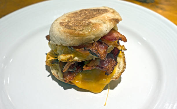 istock Breakfast Muffin Double Bacon, Eggs, Melted Cheddar Cheese on Clean White Plate 802684996