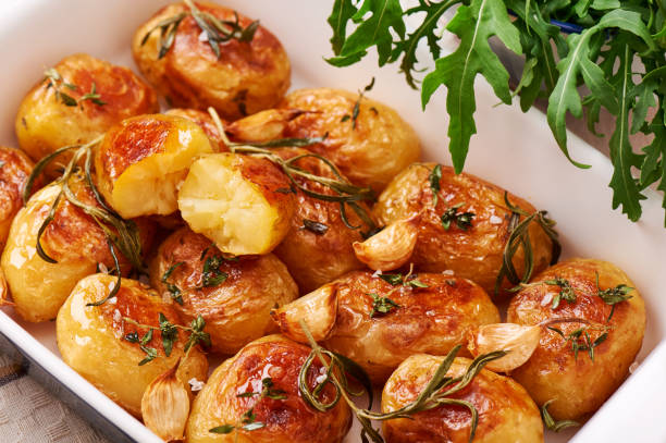 istock Roasted potatoes with garlic, thyme and rosemary in ceramic baking dish, close-up 802745274