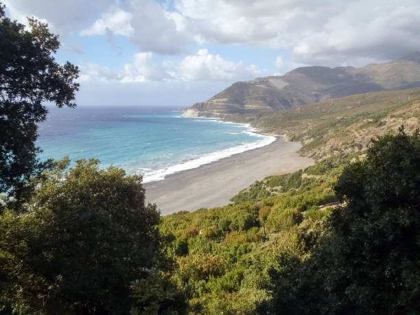 Beach with strong Mistral wind Corsica, France: Coast of Cap Corse and Nonza Beach in rough seas and strong Mistral wind mistral wind stock pictures, royalty-free photos & images