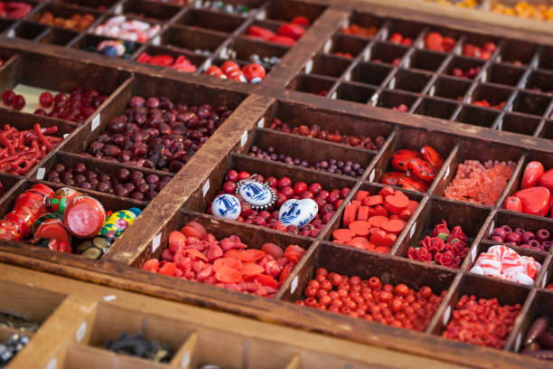 Many different beads stored in old wooden little compartments, with the focus on old Delft Blue ones.
