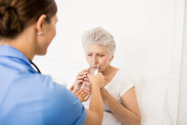 istock Nurse taking care of suffering senior patient 802763540
