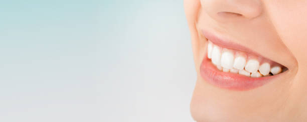 Beautiful smile young woman. White teeth on the master plan.