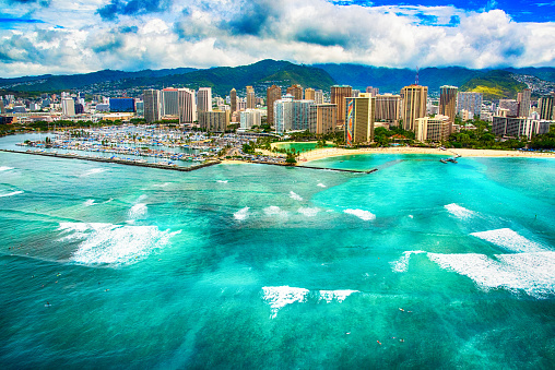 The beautiful tropical waters against the shores of downtown Honolulu shot from an altitude of about 600 feet over the ocean.