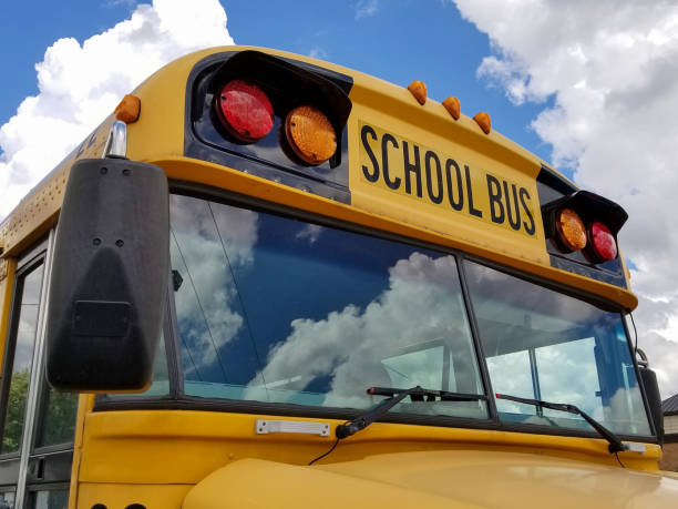 frontal view of yellow school bus front view of yellow school bus with cloud reflection in windshield empty school bus stock pictures, royalty-free photos & images