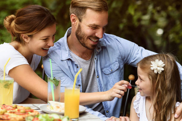 szczęśliwa mała rodzina jadalnia na zewnątrz - couple dinner summer sunlight zdjęcia i obrazy z banku zdjęć