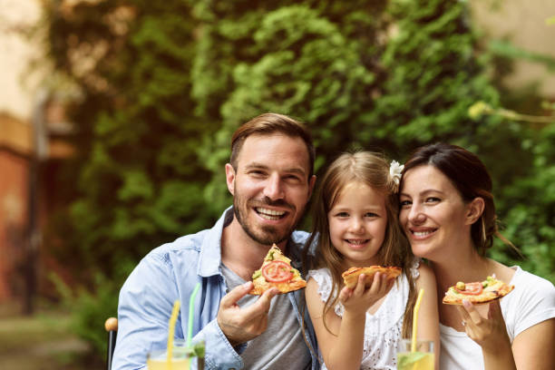 szczęśliwa rodzina jedząca na świeżym powietrzu - couple dinner summer sunlight zdjęcia i obrazy z banku zdjęć