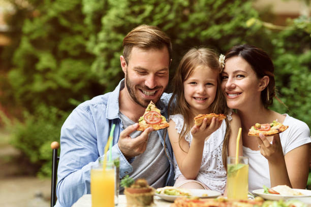 szczęśliwa rodzina jedząca na świeżym powietrzu - couple dinner summer sunlight zdjęcia i obrazy z banku zdjęć