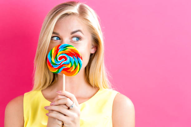 istock Young woman holding a lollipop 802801938