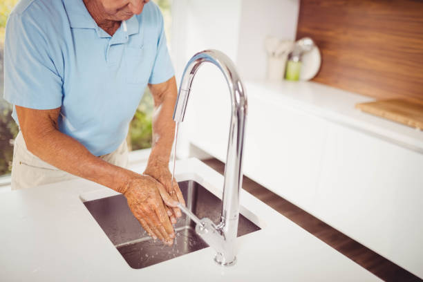 istock Mid section of senior man washing hands 802802130