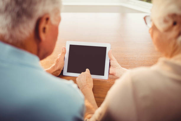 istock Rear view of senior couple using tablet 802819450