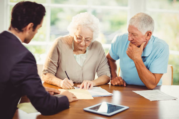 istock Senior woman signing document 802819566