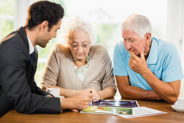 istock Businessman showing sheets to senior couple 802819580