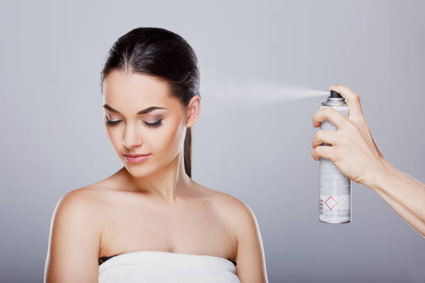Sprinkling hairspray on girl stock photo