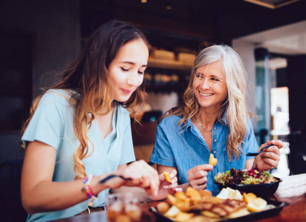 piękna starsza matka i córka jedzą lunch razem w restauracji - food healthy eating healthy lifestyle meal zdjęcia i obrazy z banku zdjęć