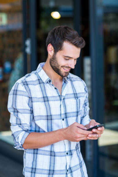 istock Hipster man using his smartphone in the city 802843676