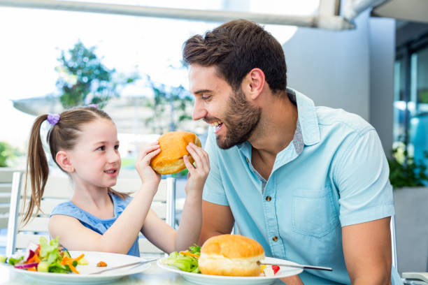 istock Daughter and father eating at the restaurant 802845990