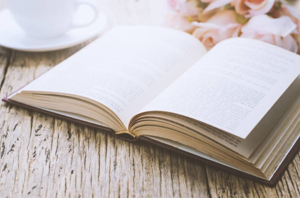 istock Opened book on wooden table with vintage tone 802857148
