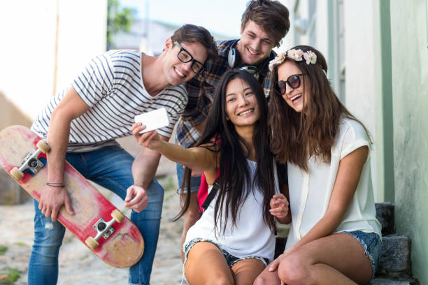 istock Hip friends taking selfie sitting on steps 802857282