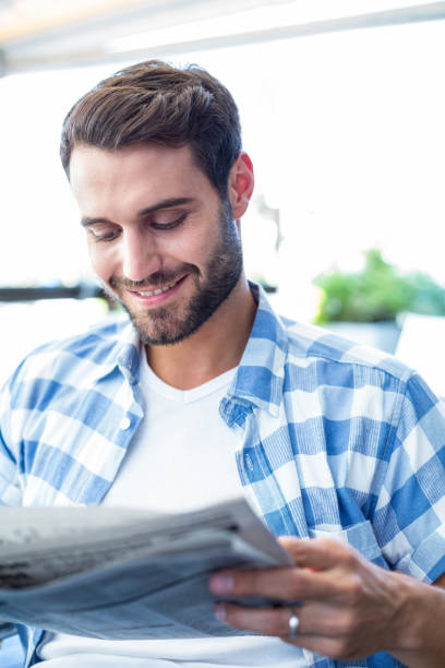 istock Young man reading the newspapers 802857298
