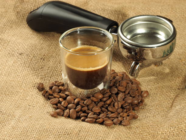 istock Coffee beans and glass mug in front of a group handle on a hessian background 802860344