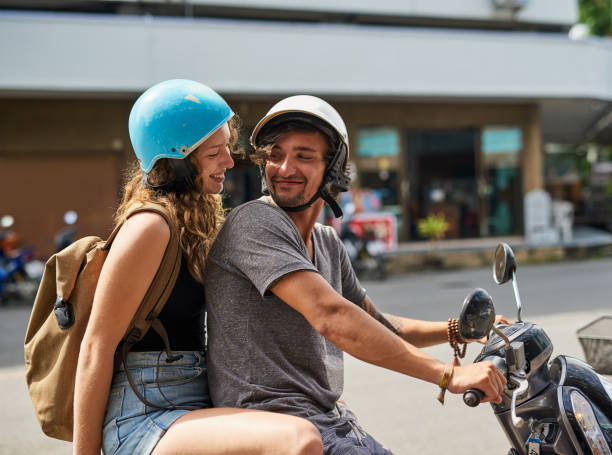 Let's go on an adventure Shot of two happy backpackers riding a motorcycle through a foreign city moped stock pictures, royalty-free photos & images