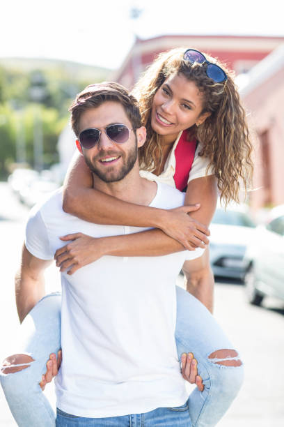istock Hip man giving piggy back to his girlfriend 802904650