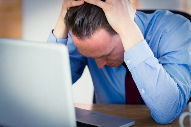 istock Stressed businessman with head in hands 802912442