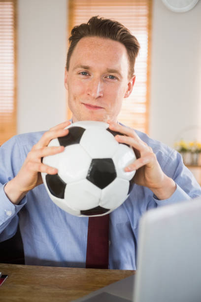 istock Cheerful businessman holding a soccer ball 802912530