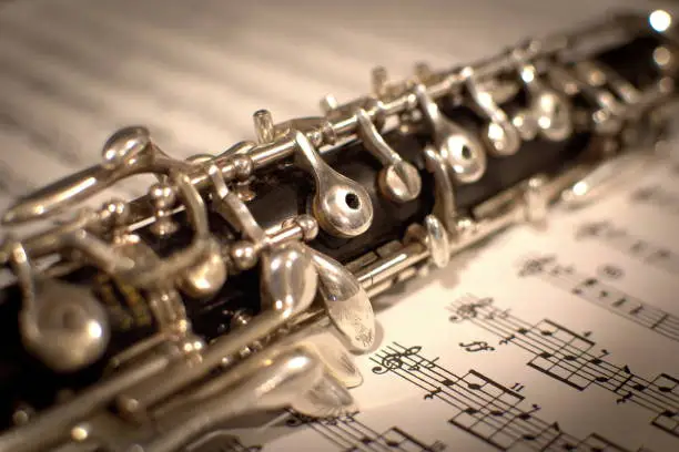 Closeup of an Oboe laid diagonally on sheet music.