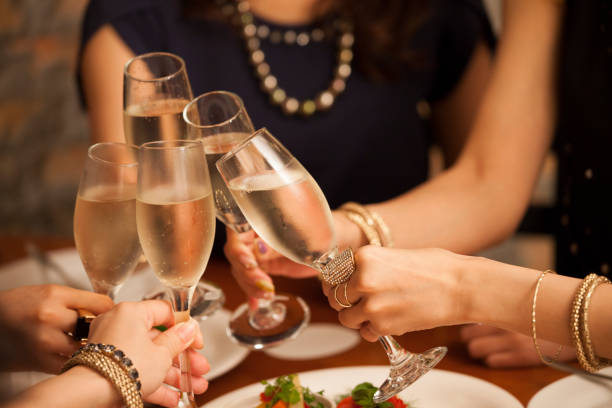 Close-up of the hands of the girls making a toast. A female college student drinking in a cafe in Tokyo. Champagne stock pictures, royalty-free photos & images