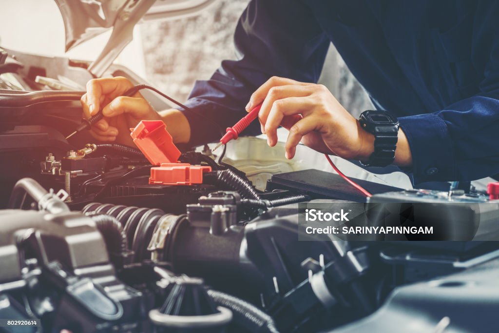 Auto mechanic checking car battery voltage Car Stock Photo