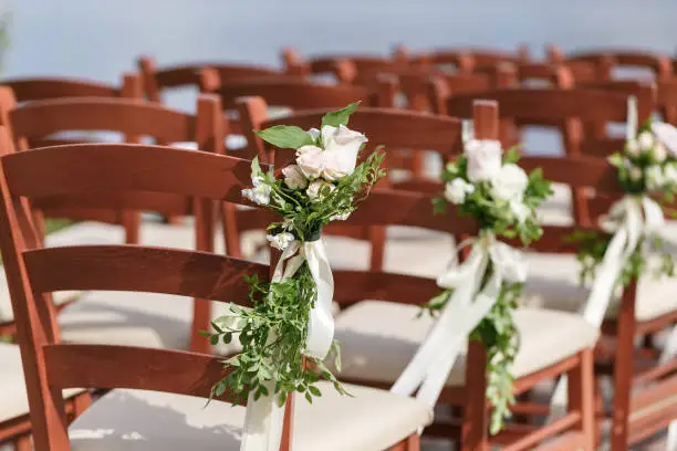 wedding decorated wooden chairs with flowers. picture with selective focus