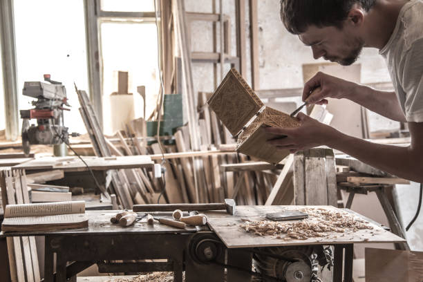 istock male carpenter working with a wood product, hand tools 802928980