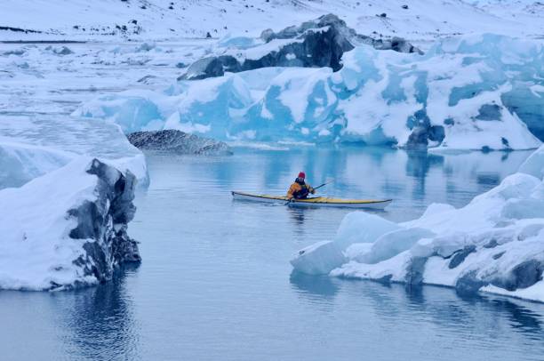 The Explorer An extreme adventurer paddles out on Jokulsarlon Lagoon in winter in Iceland at -20C. jokulsarlon stock pictures, royalty-free photos & images