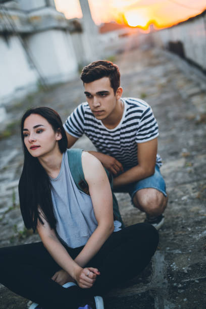istock Guy pushing girl on skateboard 802938520
