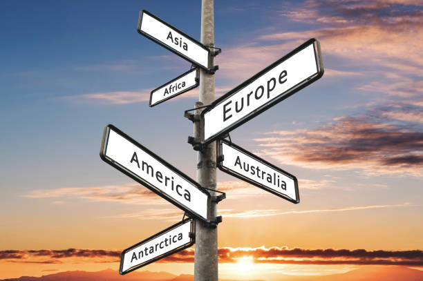istock Continents on road direction signpost, with sunset sky background 802944210