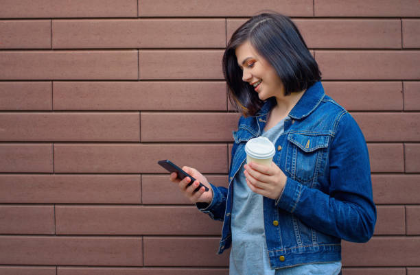 istock Smilling brunette woman with smartphone 802953274