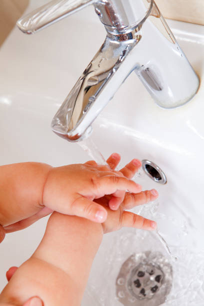 istock Children's hands under a jet of water 802960728