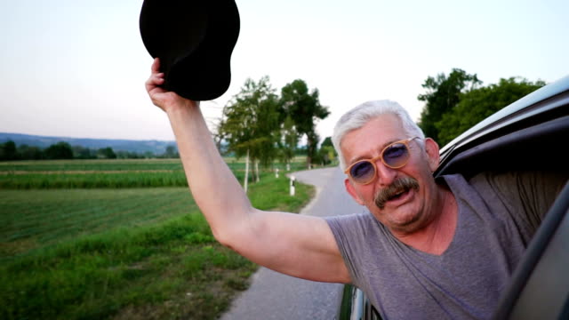 Senior man leaning out of a car window