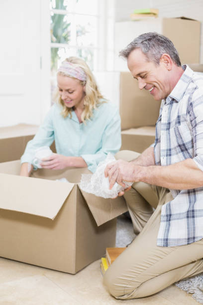 istock Smiling couple packing mug in a box 802980534
