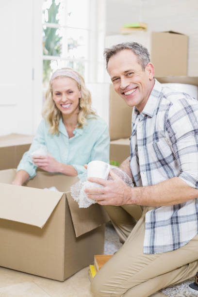 istock Smiling couple packing mug in a box 802980548