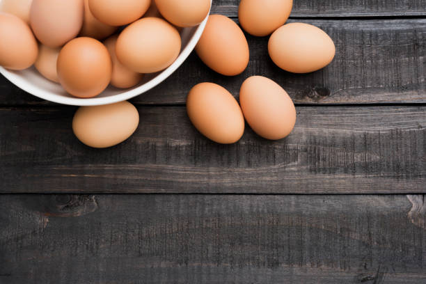 istock Fresh hen egg in white bowl and 6 hen egg out side on Black color wood table 802987474